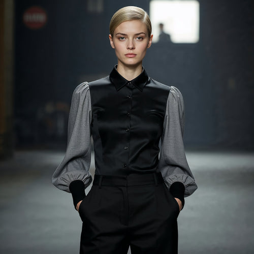 Woman wearing a black outfit with gray sleeves in a dark setting